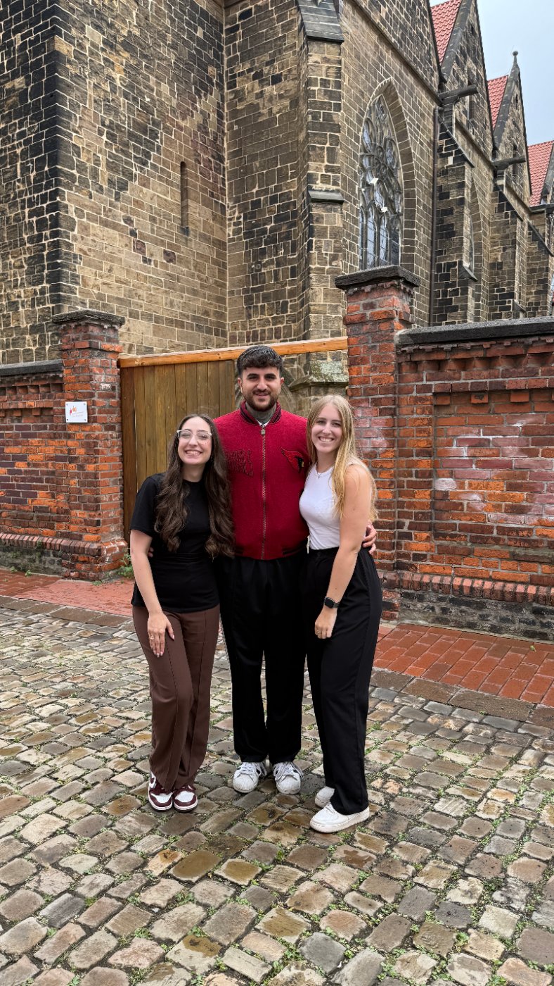 Harun Sahin mit dem About-Minden-Team vor einer Kirche in Minden